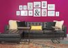 Cool City Design Sofa cushions and two small tables, with dark magenta wall behind it with pictures aquotes in frames
