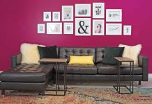 Cool City Design Sofa cushions and two small tables, with dark magenta wall behind it with pictures aquotes in frames