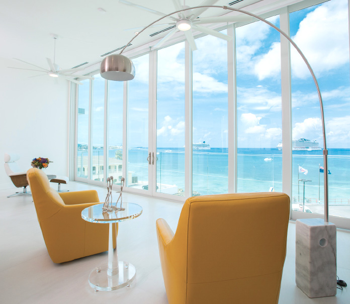 Chairs set in front of the twelve-foot floor-to-ceiling sliding glass windows giving views out to sea